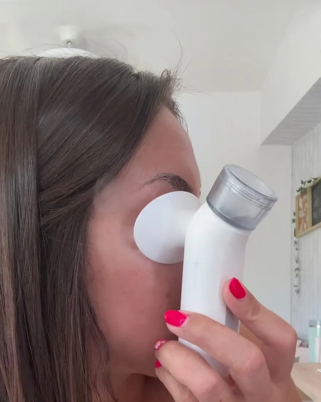 Mujer de perfil apoyándose el vaporizador sobre el ojo